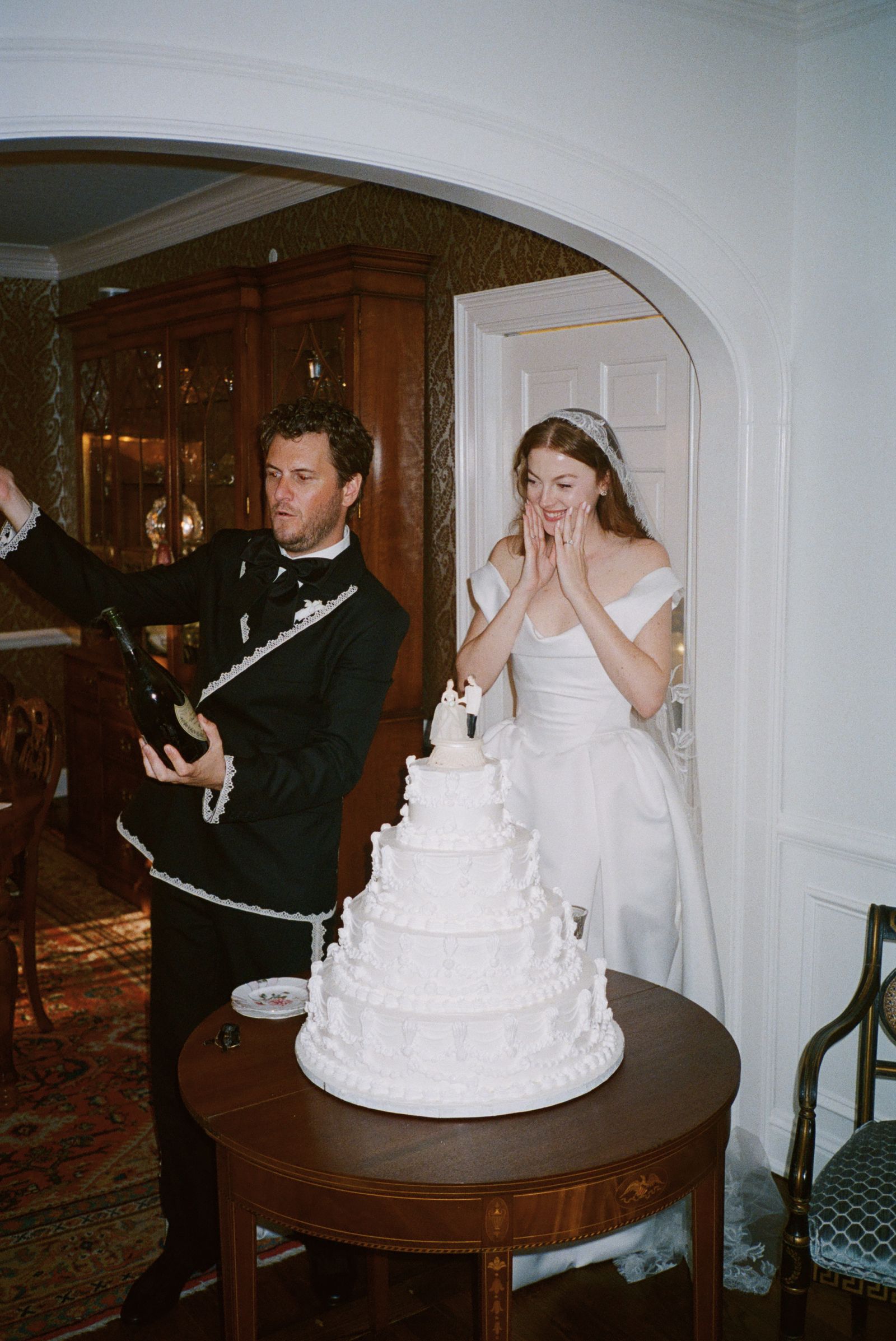 Image may contain Face Head Person Photography Portrait Clothing Formal Wear Suit Dress Cream Dessert and Food